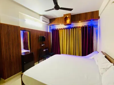 a bedroom with a white bed in a room with colorful curtains at Flat in Guruvayur- Sooryamadhavam Apartments- Family only in Guruvāyūr