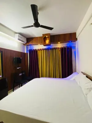 a bedroom with a large bed with a ceiling fan at Flat in Guruvayur- Sooryamadhavam Apartments- Family only in Guruvāyūr