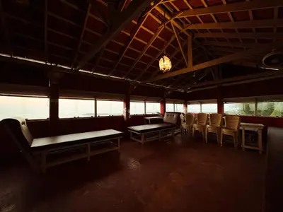 a room with chairs and benches in a building at SeaCret by Dormer Stay in Kozhikode