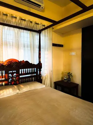 a bedroom with a large bed with a window at SeaCret by Dormer Stay in Kozhikode