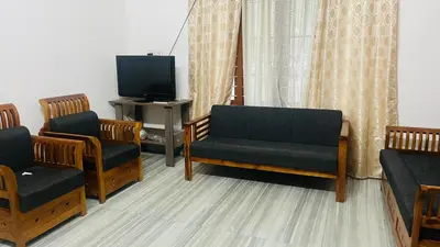 a living room with three chairs and a tv at Johnnys Destination in Angamali