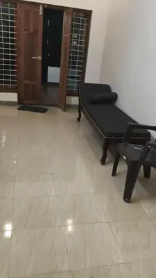 a living room with a chair and a door at Johnnys Destination in Angamali