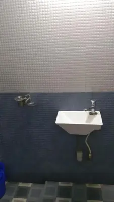 a bathroom with a white sink in a blue wall at Charis Guest house near Guruvayur, Kunnamkulam in Kunnamkulam