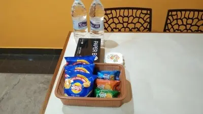 a lunch box with snacks and water bottles on a table at Charis Guest house near Guruvayur, Kunnamkulam in Kunnamkulam