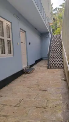 a stairway leading up to a white building with a door at Charis Guest house near Guruvayur, Kunnamkulam in Kunnamkulam