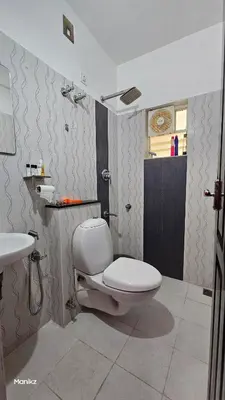 a bathroom with a toilet and a sink at Kulipini Family Apartment in Irinjālakuda