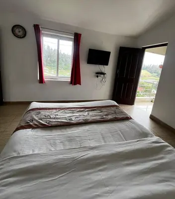 a large bed in a bedroom with a window at Hideaway Home43 in Ooty