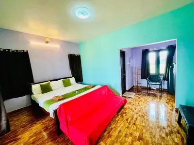 a bedroom with a bed with a red blanket on it at Teyt Castle - Ooty - Nilgiris in Ooty