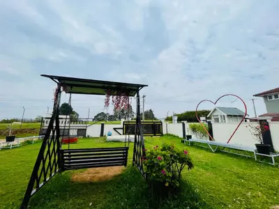 a garden with a gazebo and a swing at Teyt Castle - Ooty - Nilgiris in Ooty