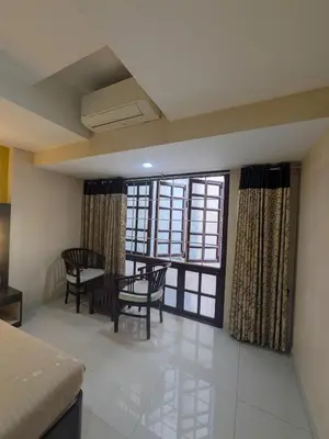 a room with a table and chairs and a window at Hotel TriColors Ramnagar Gandhipuram in Coimbatore