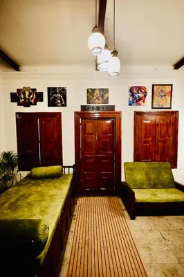a living room with two beds and a couch at Idanazhi the corridor in Kozhikode