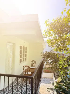 a balcony of a house with a table and chairs at Paradise Premium Villa Munnar in Munnar