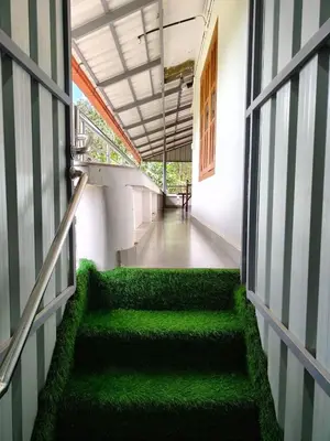 a hallway with green stairs in a building at whisperingstrem's RIVER view homestay in Padinjarathara