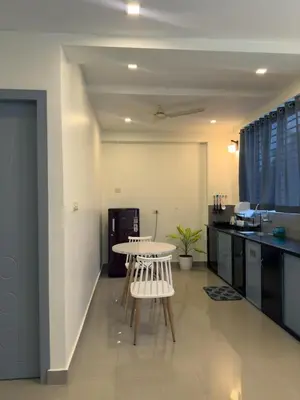 a kitchen with a table and chairs in a room at Crest By Irishighes in Perintalmanna