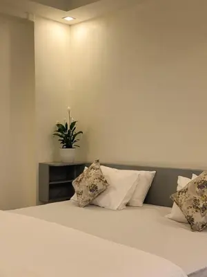 a bedroom with a bed with a potted plant on it at Crest By Irishighes in Perintalmanna