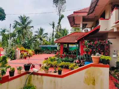 a garden outside a building with potted plants at Cozy Coffee Estate Homestay Coorg Madikeri in Madikeri