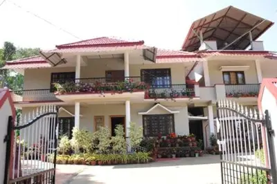 a large white house with flowers on the balcony at Cozy Coffee Estate Homestay Coorg Madikeri in Madikeri
