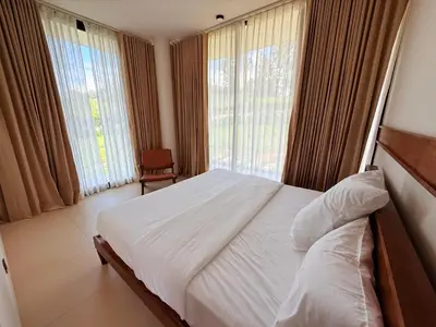 a bedroom with a white bed and large windows at Ozone The Misty Villa - Hill View in Coonoor