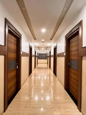 a corridor of a hospital with wooden doors at Shri Amman Residency in Dhārāpuram