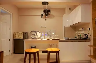 a kitchen with two chairs and a table in it at Lavender Airport suite in Nedumbassery