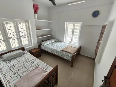 a room with two beds and two windows at Resonanace Homestay Nature Stay in Wayanad in Pulpally