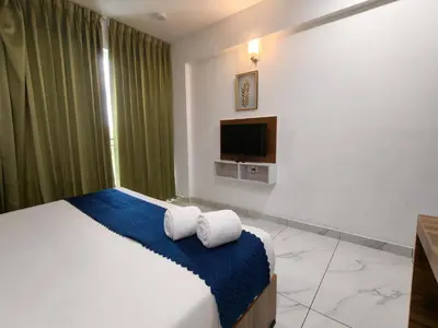 a bedroom with a bed and a tv at Nirvanica Retreat Wayanad in Padinjarathara