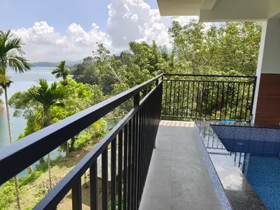 a balcony with a view of the water at Nirvanica Retreat Wayanad in Padinjarathara