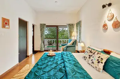a living room with a couch and a cat on a table at SaffronStays Chamomile Hills in Kotagiri