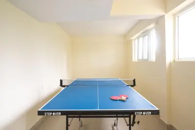 a ping pong table in the middle of a room at SaffronStays Chamomile Hills in Kotagiri