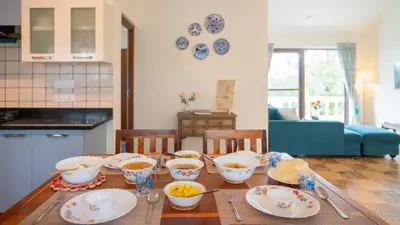 a table with bowls of food in a kitchen at SaffronStays Chamomile Hills in Kotagiri