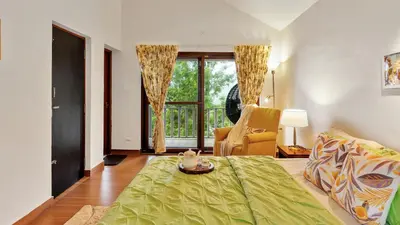 a living room with a bed and a window at SaffronStays Chamomile Hills in Kotagiri
