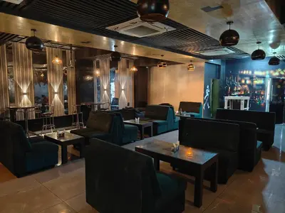 a restaurant with couches and tables and a bar at RR Grand Inn in Coimbatore