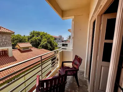 a balcony with two chairs and a door at Rohi stays 2 bed room flats in Mysore