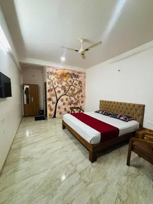 a bedroom with a bed and a painting on the wall at Apple Tower Stays in Meppādi