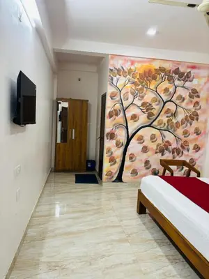 a room with a bed and a painting on the wall at Apple Tower Stays in Meppādi