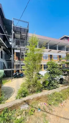 a building with a tree in front of it at Apple Tower Stays in Meppādi