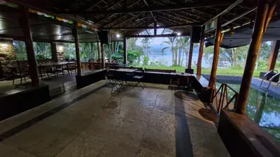 a room with chairs and tables in a building at Grace Backwater Villa Coorg in Suntikoppa