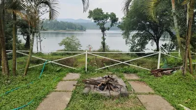 a fence next to a body of water at Grace Backwater Villa Coorg in Suntikoppa