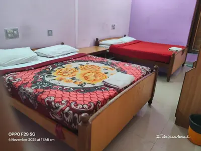 two beds in a small room with at Hotel Srusti Residency in Mysore