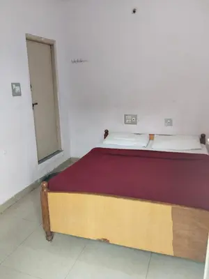a large bed in a white room with a window at Hotel Srusti Residency in Mysore