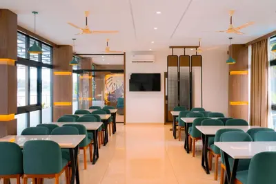 a classroom with tables and chairs and a screen at Rivera resort and wellness center in Kodanad