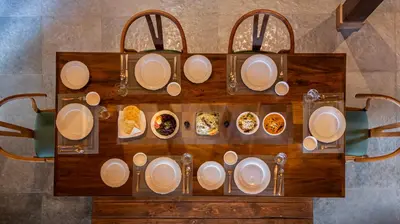 an overhead view of a table with plates of food at amã Stays & Trails - Iris Villa, Kozhikode in Puthuppādi