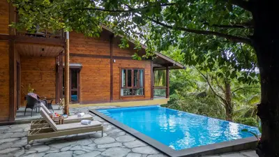 a villa with a swimming pool next to a house at amã Stays & Trails - Iris Villa, Kozhikode in Puthuppādi