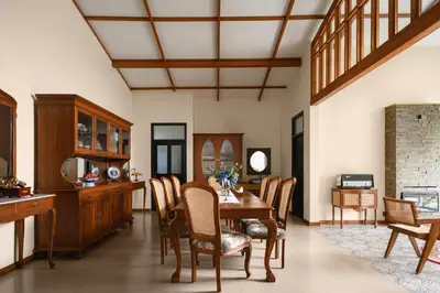 a dining room with a wooden table and chairs at amã Stays & Trails - Mount Pleasant, Coonoor in Coonoor