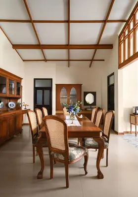 a dining room with a wooden table and chairs at amã Stays & Trails - Mount Pleasant, Coonoor in Coonoor