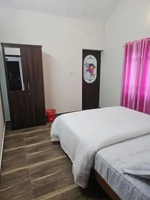 a bedroom with a bed and a dresser and purple curtains at Mount Wave Holiday Pool Villa in Wayanad