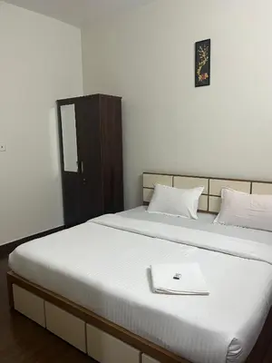 a bedroom with a bed with a book on it at Mount Wave Holiday Pool Villa in Wayanad