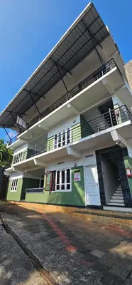 a white and green building with balconies on it at Vythiri saara inn in Vythiri