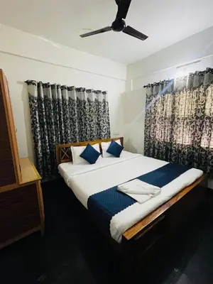 a bedroom with a bed with a ceiling fan at Vythiri saara inn in Vythiri