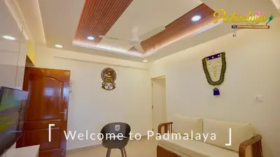 a living room with a coffered ceiling and a couch at Padmalaya Homestay ! in Guruvāyūr